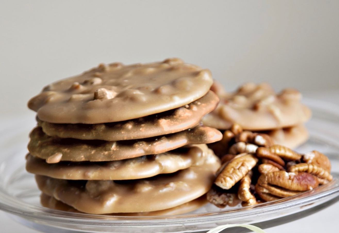 a stack of cookies and nuts on a glass plate